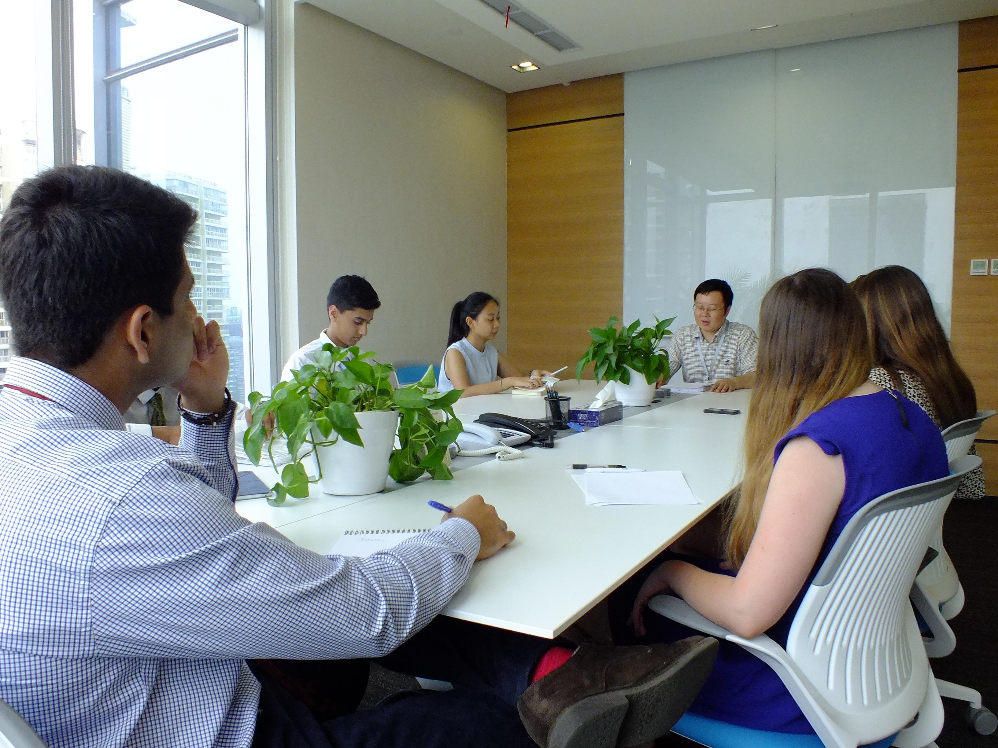A group of teenage interns participate in a meeting with business professionals at a company in Chengdu, China. Business professionals working for a company in China involve teenage Projects Abroad interns in a meeting.